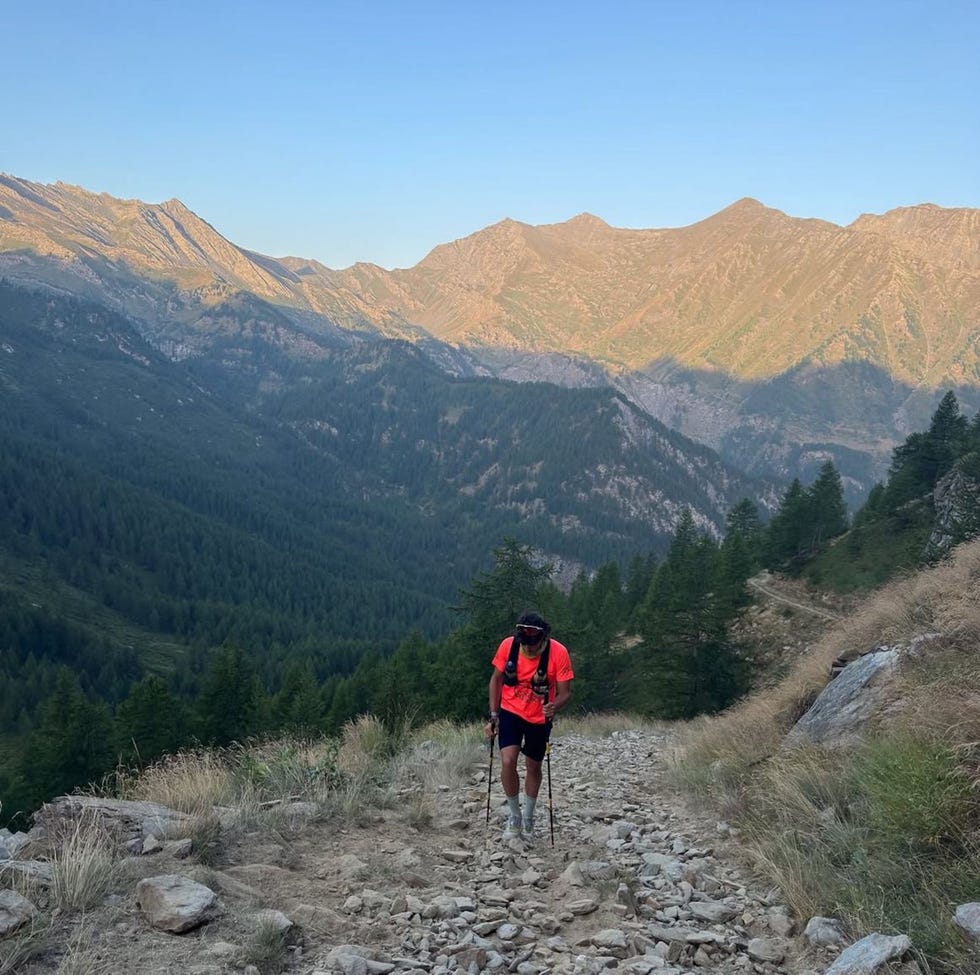 hiker climbing a rocky trail in the mountains