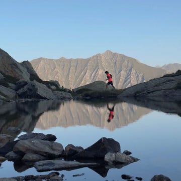 a person running alongside a serene mountain lake a person running alongside a serene mountain lake