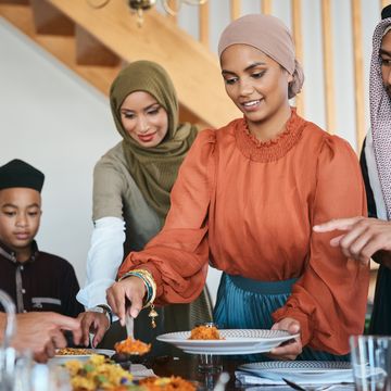 shot of a muslim family dishing lunch for themselves on eid al fitr