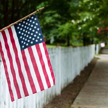 american flag hanging over a fence