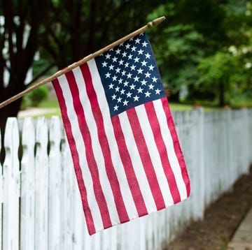 american flag hanging over a fence