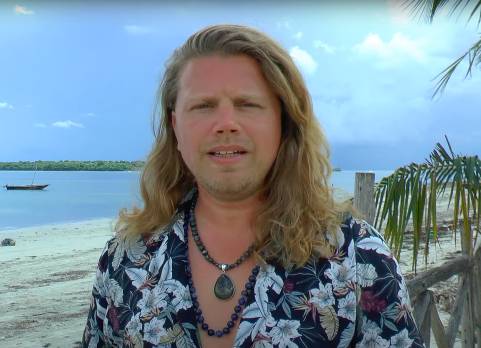 a man with long hair on a beach