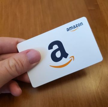 where to buy amazon gift cards, person holding a white amazon gift card