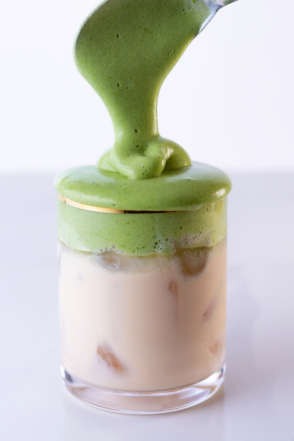 Premium Photo  Iced green tea matcha dalgona in two glasses with a straw  and a bowl of matcha powder for cooking on a wooden tray white background  space for text