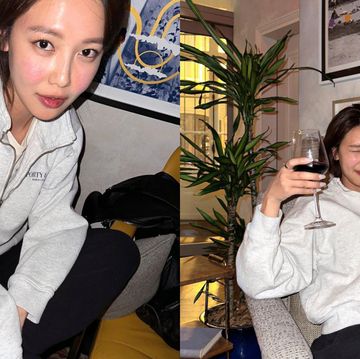 a couple of women sitting on a couch and holding a glass of wine