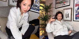 a couple of women sitting on a couch and holding a glass of wine
