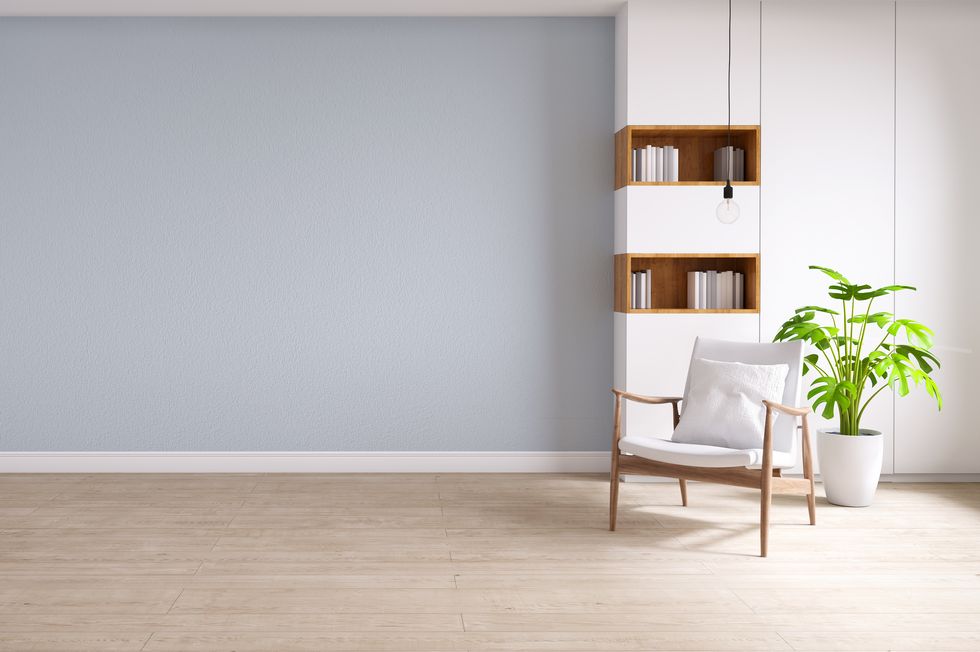 white armchair  on wood flooring and pastel blue wall, minimalist and vintage interior
