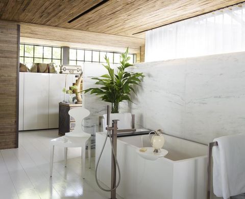 marble tub surround and wooden walls and ceilings in a modern white bathroom