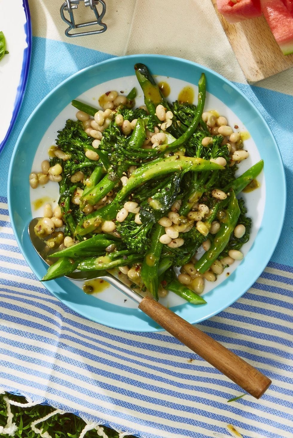 white bean and broccolini salad on a white and blue plate