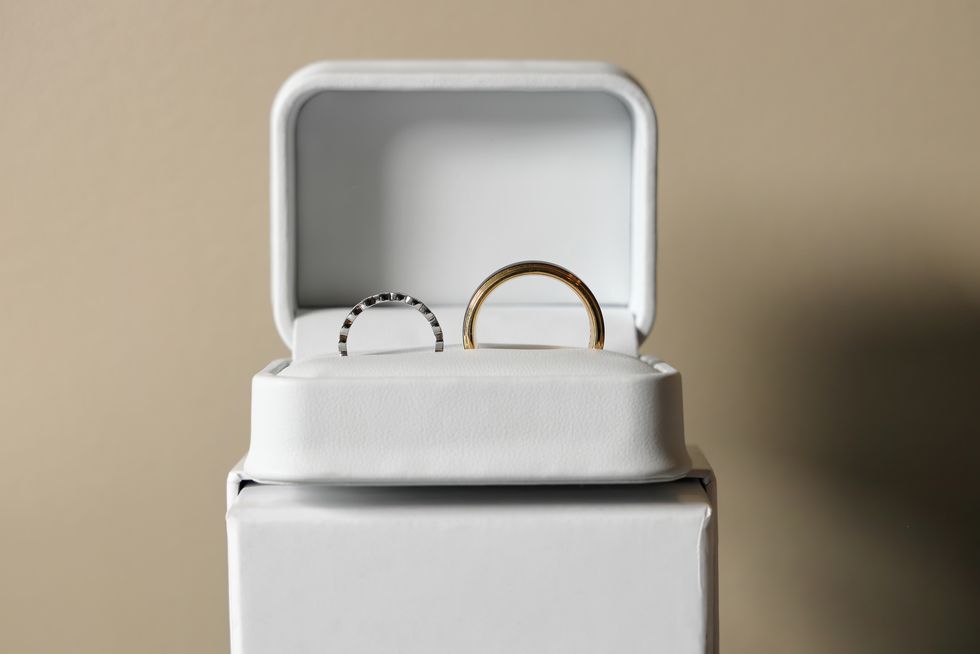 white box with silver and gold weding rings with a plain background