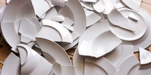 white broken plates on a wooden floor