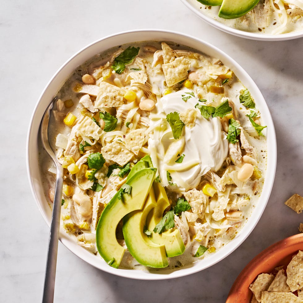 white chicken chili with cilantro, chips, sour cream and avocado
