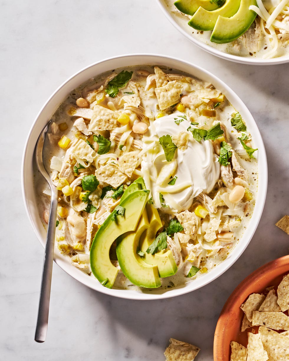 white chicken chili with cilantro, chips, sour cream and avocado