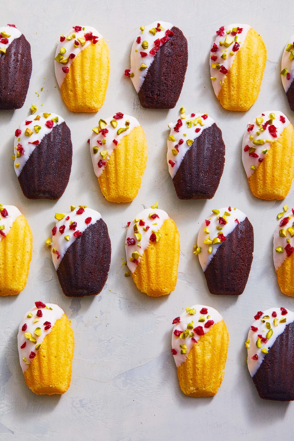 white chocolate dipped madeleines with dried fruits and nuts sprinkled on top