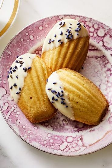 white chocolate and lavender madeleines on a pink plate