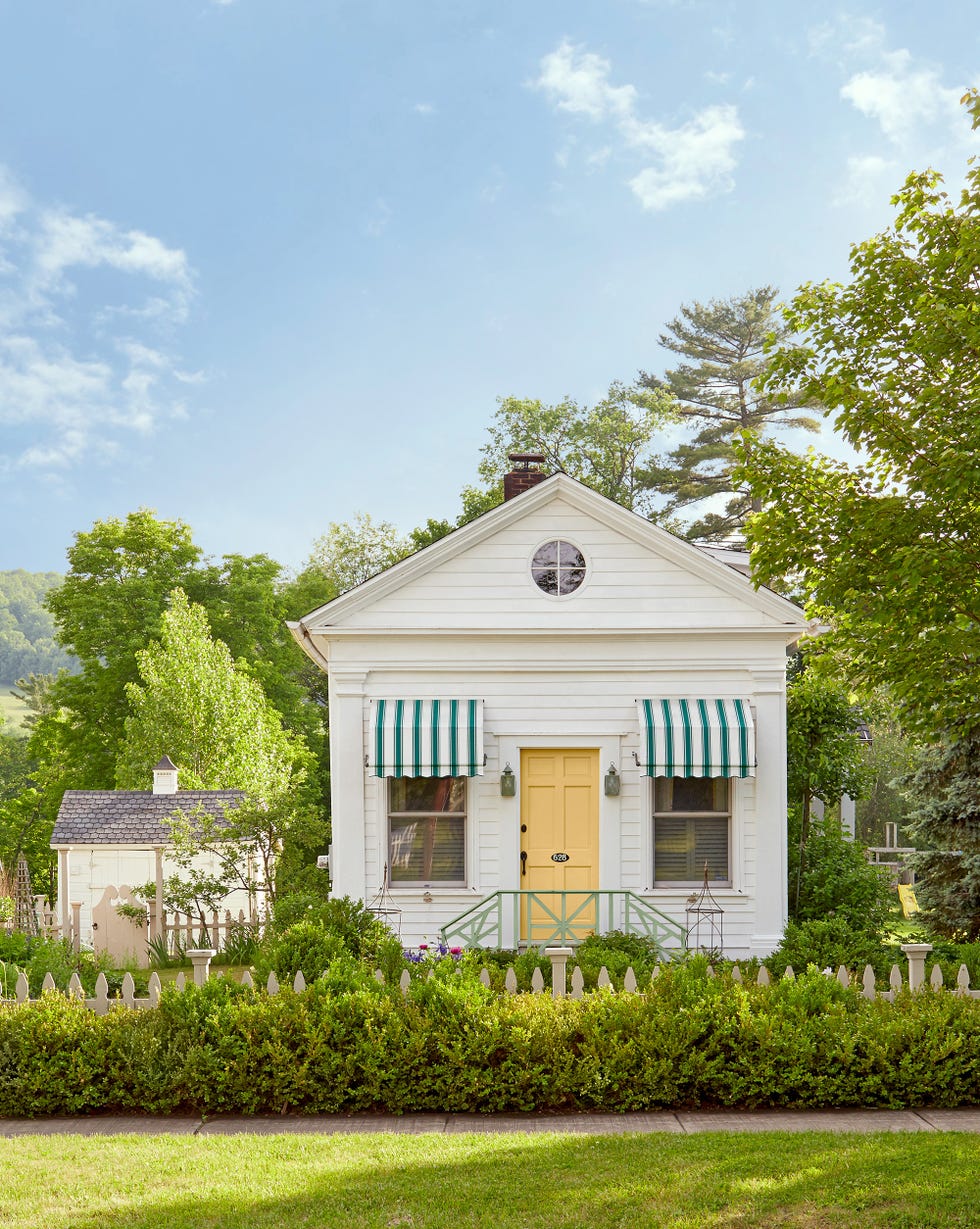 white clapboard cottage with yellow door