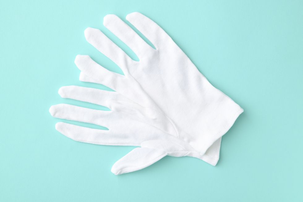 White cotton gloves on light blue background