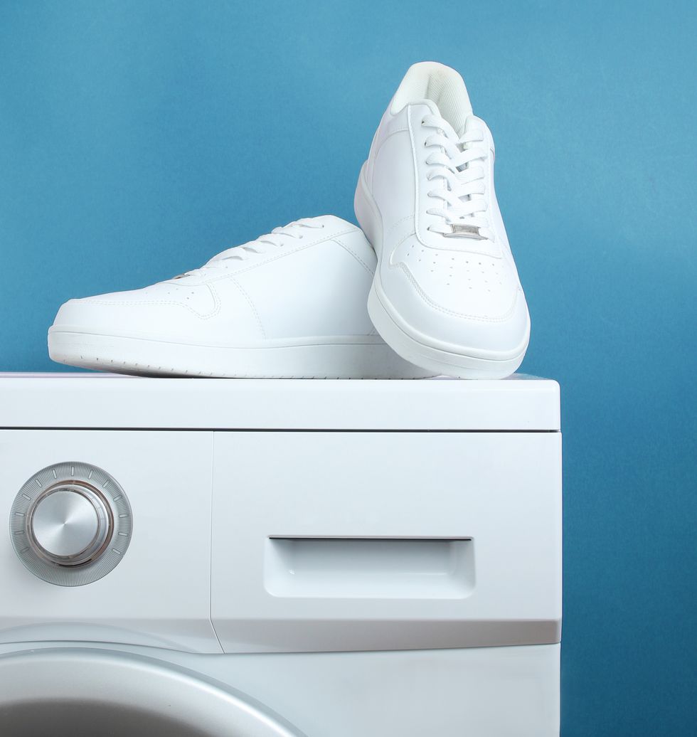 white fashion sneakers on the washing machine against blue background