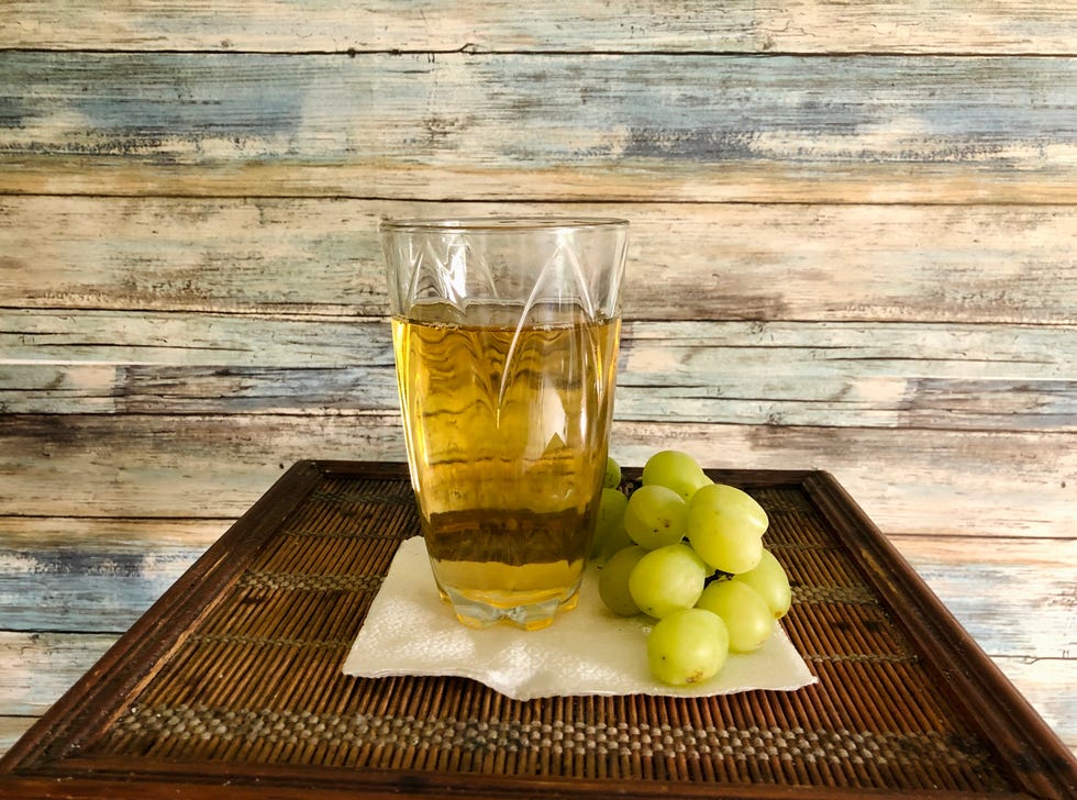 white grape juice and grapes with retro blue background