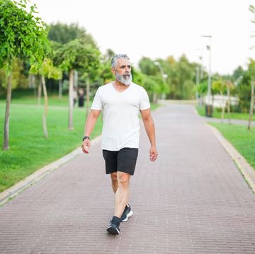 white haired and bearded man walking in the park