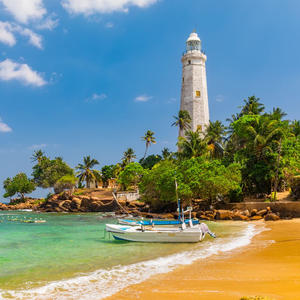 white lighthouse dondra head and tropical palms, sri lanka
