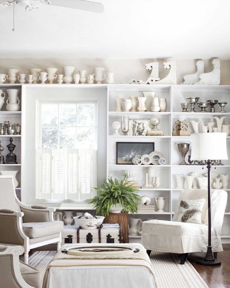 a white living room with shelves filled with white pottery