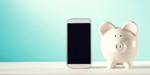 white piggy bank with a smart phone