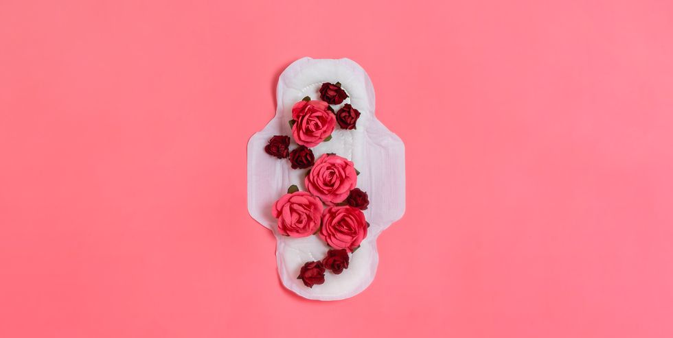 white sanitary pad with red and pink flowers on it, woman health or body positive concept pink background flatlay copyspace