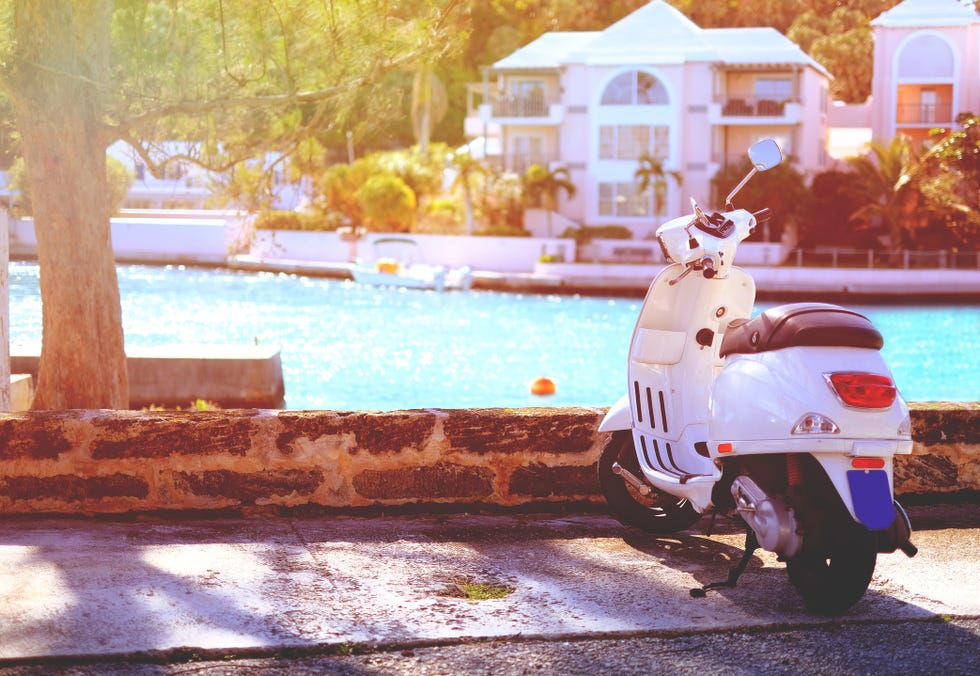 white scooter parked by the waterside