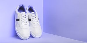 white sport sneakers shoes on the violet background fitness background