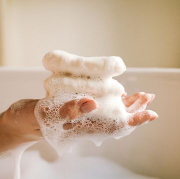 white toilet soap in female hands against the background of a fragrant foam bath natural beauty, daily skincare routine moisturizing, cleansing