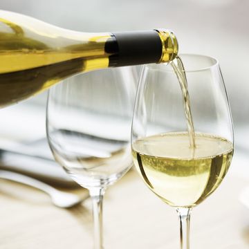 white wine is pouring into wineglass
