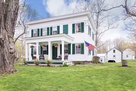white house with dark green door and shutters