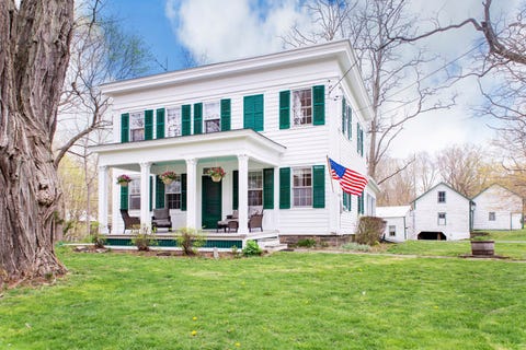 white house with dark green door and shutters