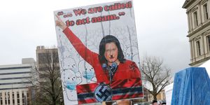 topshot   a protestor with a sign that has michigan gov gretchen whittmer depicted as adolph hitler is seen at an american patriot rally organized by michigan united for liberty protest for the reopening of businesses, on the steps of the michigan state capitol in lansing, michigan on april 30, 2020   the group is upset with michigan gov gretchen whitmer's mandatory closure to curtail covid 19 photo by jeff kowalsky  afp photo by jeff kowalskyafp via getty images