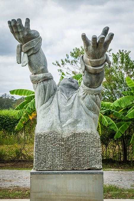 whitney plantation museum, statue of slave with hands raised