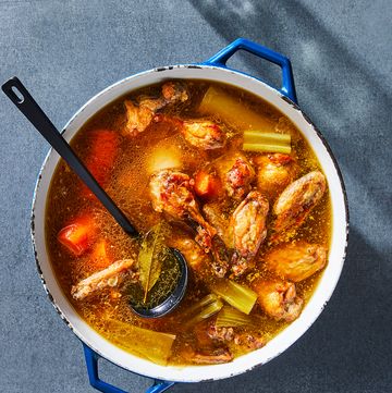 bone broth in a stock pot with chicken, carrots, and celery