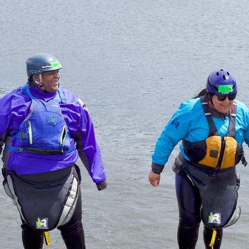 ebony joy igbinoba and another person from first descents wearing rafting gear at a river