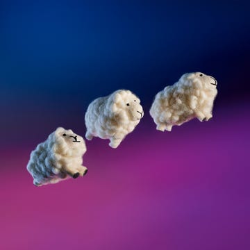 three wool sheep toys jumping through the air with a night sky background