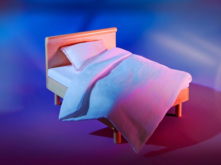 dollhouse bed on a purple and blue background with a shadow of a window