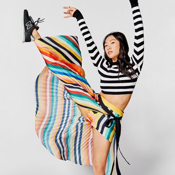 olivia liang wearing a striped outfit, kicking her leg in the air