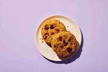 two oatmeal cookies on a plate against a purple background