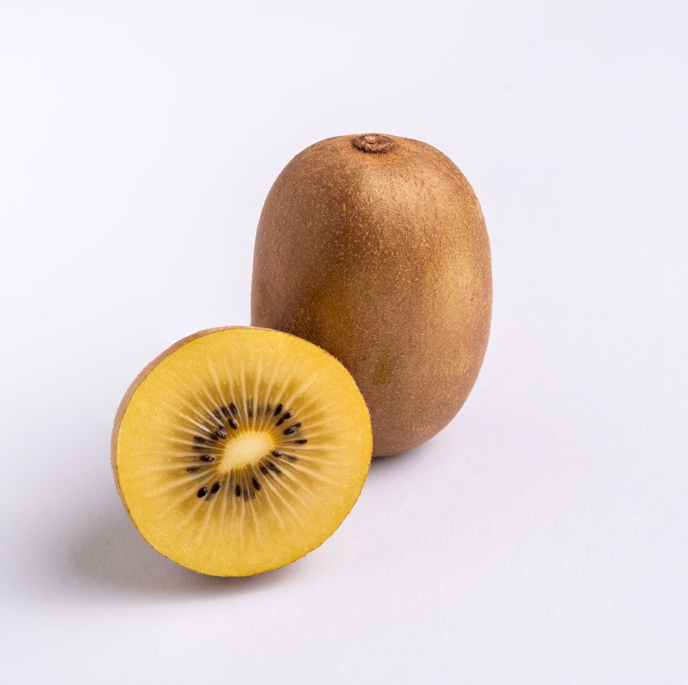 whole and half of yellow or gold kiwi fruit isolated on white,amsterdam,netherlands