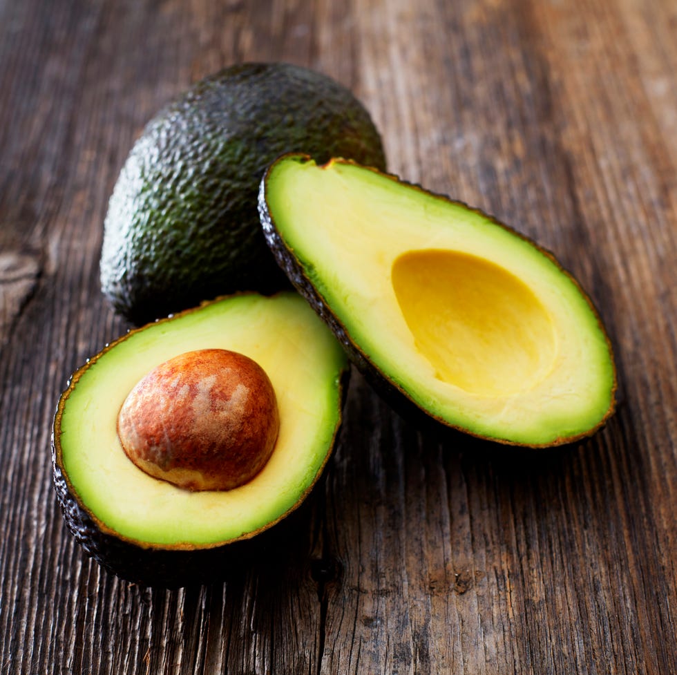 Whole and sliced avocado on wood Whole and sliced avocado on wood