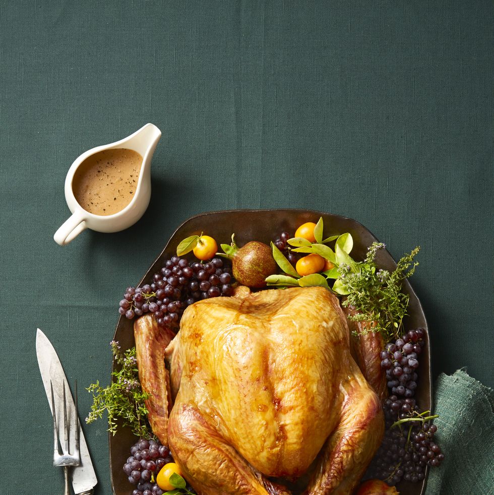 https://hips.hearstapps.com/hmg-prod/images/whole-roast-turkey-on-platter-with-garnishes-and-green-tablecoth-1599755530.jpg?crop=1.00xw:0.667xh;0,0.221xh&resize=980:*