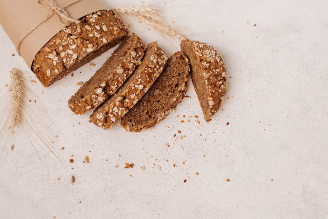 pan integral con avena encima junto a trigo decorativo