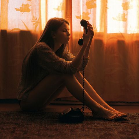 a person sitting on the floor holding a phone