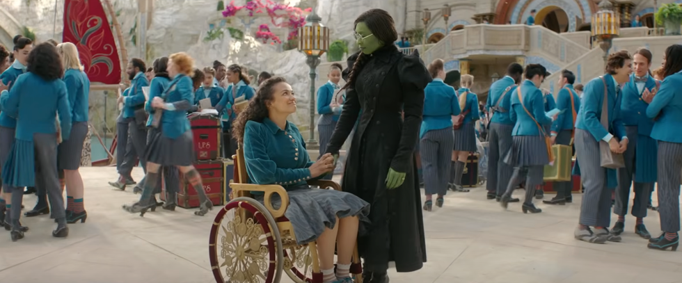 Scene in a busy school environment with a girl in a wheelchair talking to a standing figure