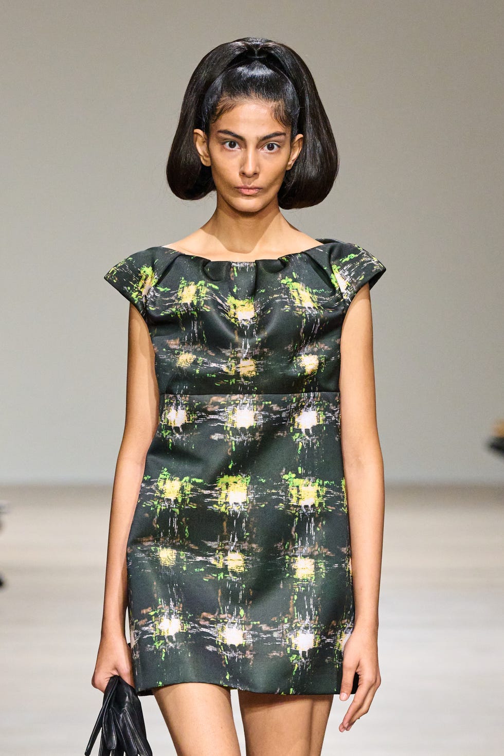 a model showcases a stylish black dress with abstract patterns