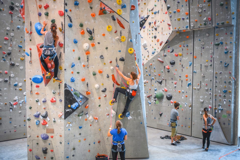 wide angle view of sportspeople ascending climbing wall